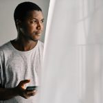 Millennial Buyers - man in gray crew neck shirt standing beside white curtain