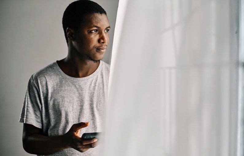Millennial Buyers - man in gray crew neck shirt standing beside white curtain