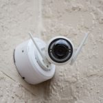Security Camera - white surveillance camera hanging on wall