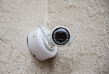 Security Camera - white surveillance camera hanging on wall