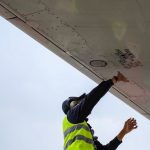 Maintenance Request - man in green safety vest standing under white structure