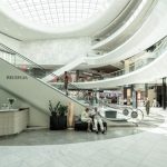 Shopping Center - person sitting on chair beside escalator