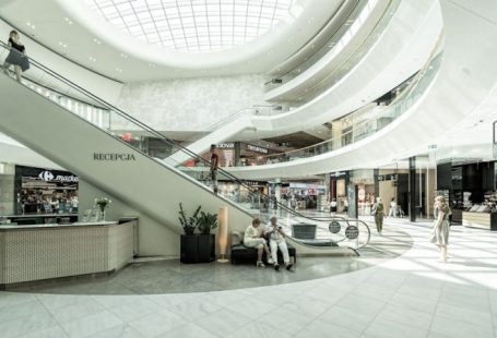 Shopping Center - person sitting on chair beside escalator
