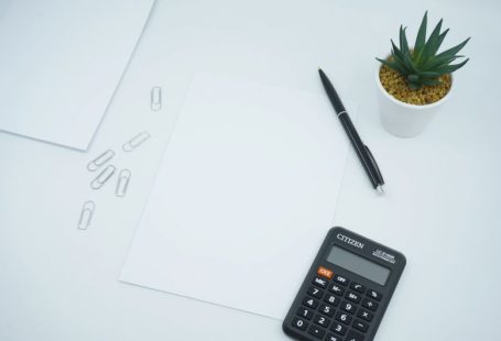 Mortgage Calculator - black calculator beside black pen on white printer paper