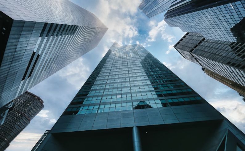 Office Buildings - low angle photography of high rise building under white clouds during daytime