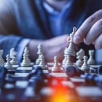 Negotiation Strategy - depth of field photography of man playing chess