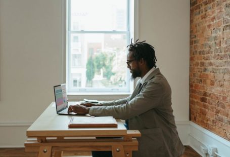 Home Office - a person sitting at a desk with a laptop and papers