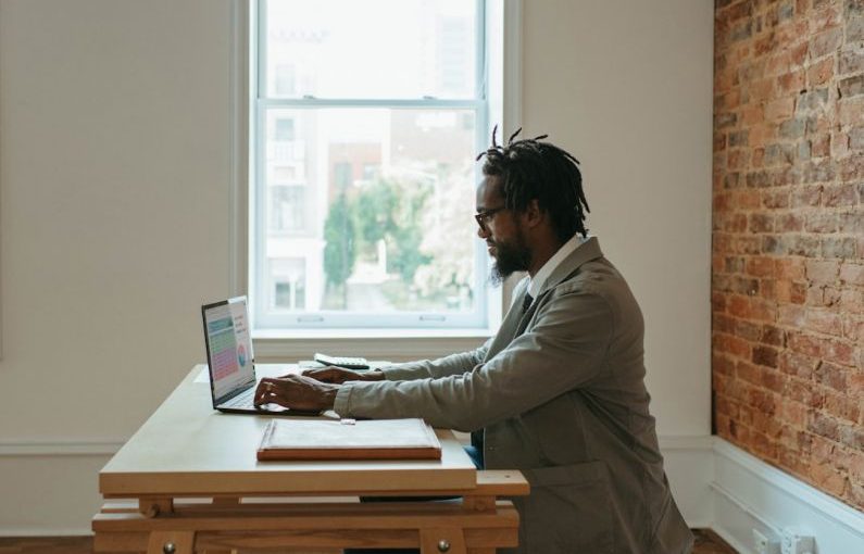 Home Office - a person sitting at a desk with a laptop and papers
