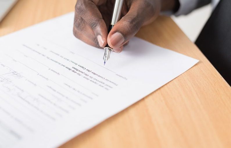Legal Documents - person writing on white paper