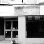 Foreclosure Sign - a person sitting on the ground in front of a building
