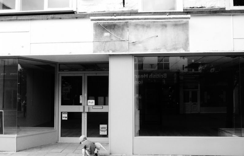 Foreclosure Sign - a person sitting on the ground in front of a building