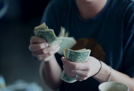 Passive Income - focus photography of person counting dollar banknotes