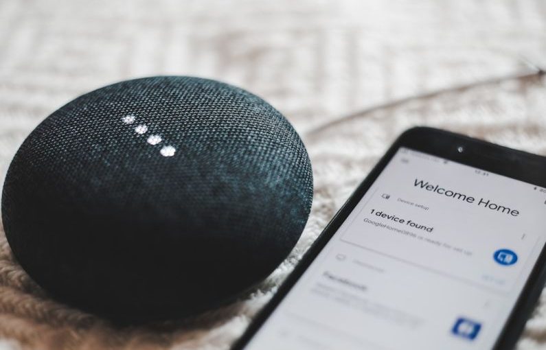 Smart Home - turned-on charcoal Google Home Mini and smartphone
