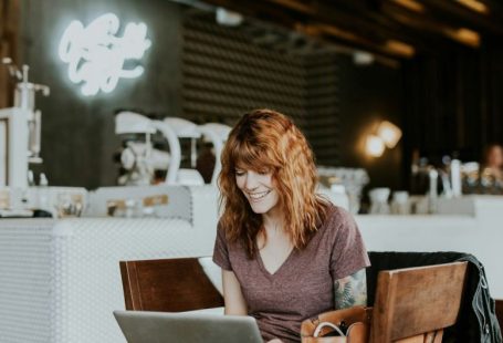 Online Notarization - woman sitting on brown wooden chair while using silver laptop computer in room